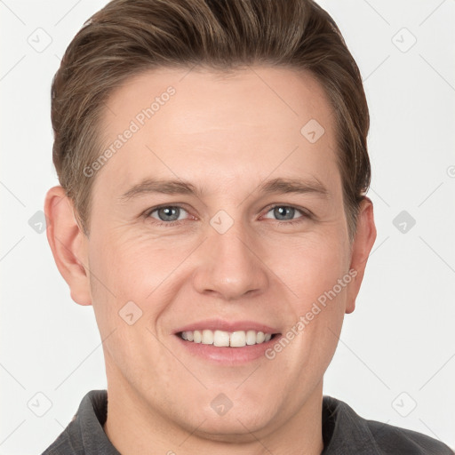 Joyful white young-adult male with short  brown hair and grey eyes