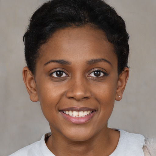 Joyful black young-adult female with short  brown hair and brown eyes