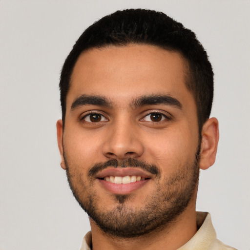 Joyful latino young-adult male with short  black hair and brown eyes