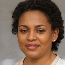 Joyful black adult female with medium  brown hair and brown eyes