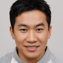 Joyful asian young-adult male with short  brown hair and brown eyes