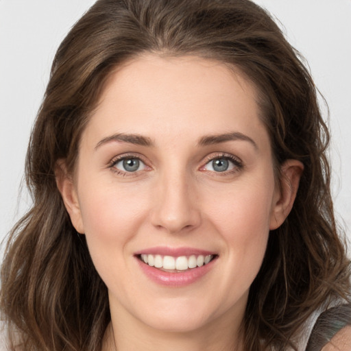 Joyful white young-adult female with long  brown hair and grey eyes