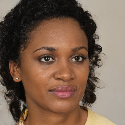 Joyful black young-adult female with medium  brown hair and brown eyes