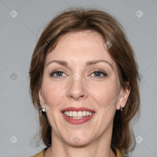 Joyful white adult female with medium  brown hair and grey eyes