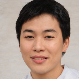 Joyful asian young-adult male with short  brown hair and brown eyes