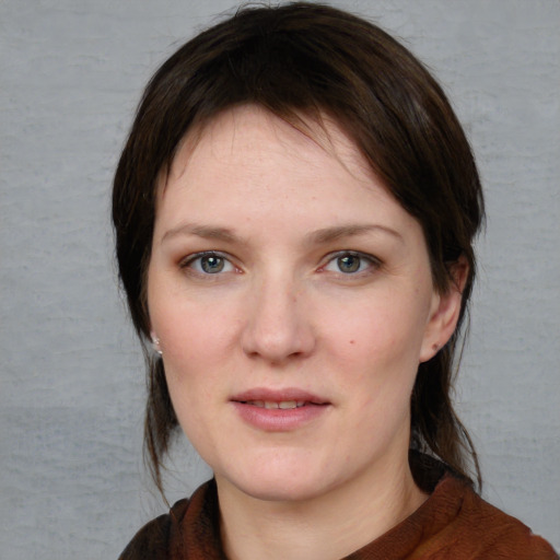 Joyful white young-adult female with medium  brown hair and blue eyes