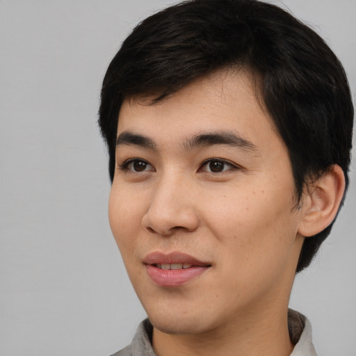 Joyful asian young-adult male with short  black hair and brown eyes