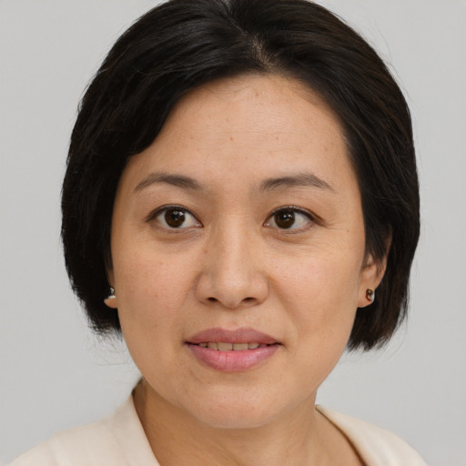 Joyful asian adult female with medium  brown hair and brown eyes