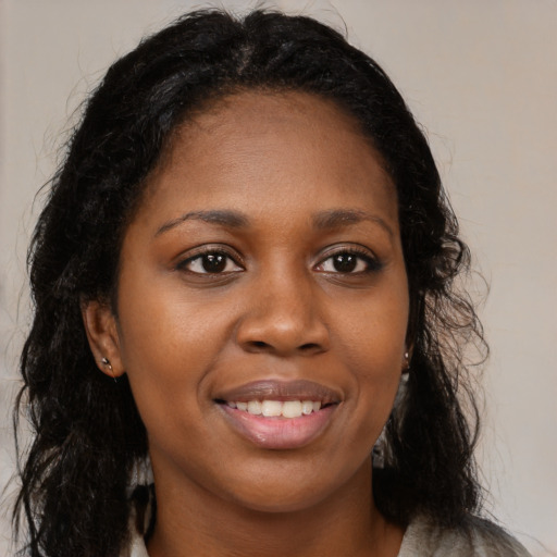 Joyful black young-adult female with long  brown hair and brown eyes