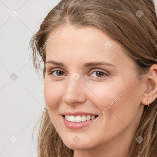 Joyful white young-adult female with long  brown hair and brown eyes