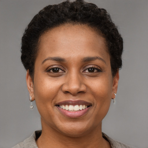 Joyful black young-adult female with short  brown hair and brown eyes