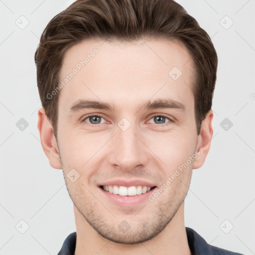 Joyful white young-adult male with short  brown hair and grey eyes