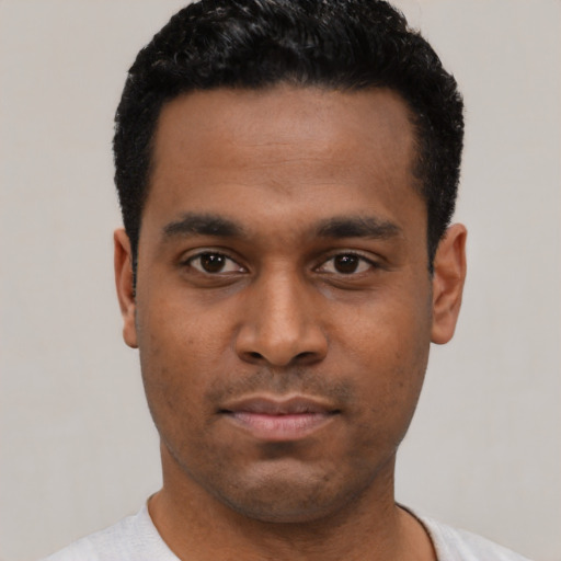 Joyful latino young-adult male with short  black hair and brown eyes