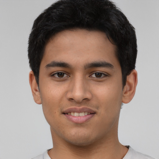 Joyful latino young-adult male with short  black hair and brown eyes