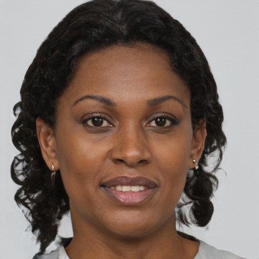 Joyful black adult female with medium  brown hair and brown eyes