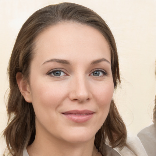 Joyful white young-adult female with medium  brown hair and grey eyes