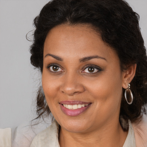 Joyful black young-adult female with long  brown hair and brown eyes