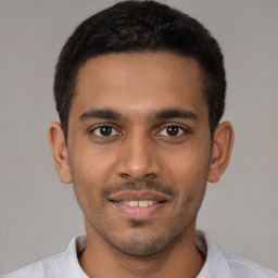 Joyful latino young-adult male with short  brown hair and brown eyes