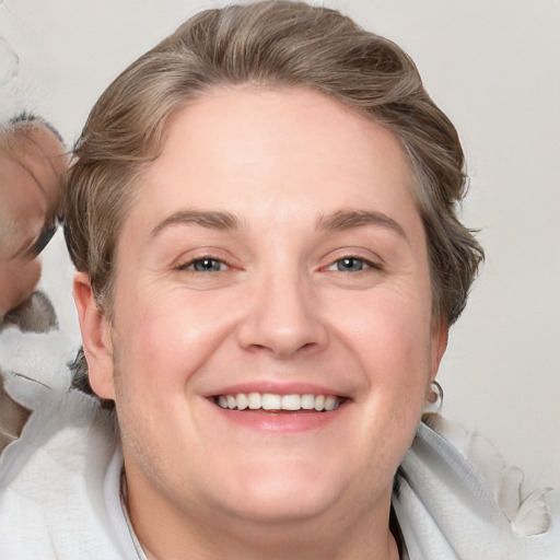 Joyful white adult female with short  brown hair and blue eyes