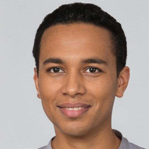 Joyful black young-adult male with short  black hair and brown eyes