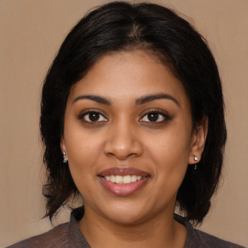 Joyful black young-adult female with medium  black hair and brown eyes