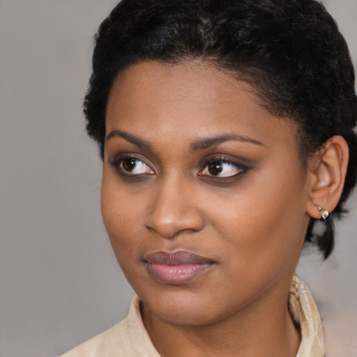 Joyful black young-adult female with short  black hair and brown eyes