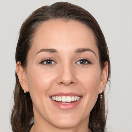 Joyful white young-adult female with medium  brown hair and grey eyes