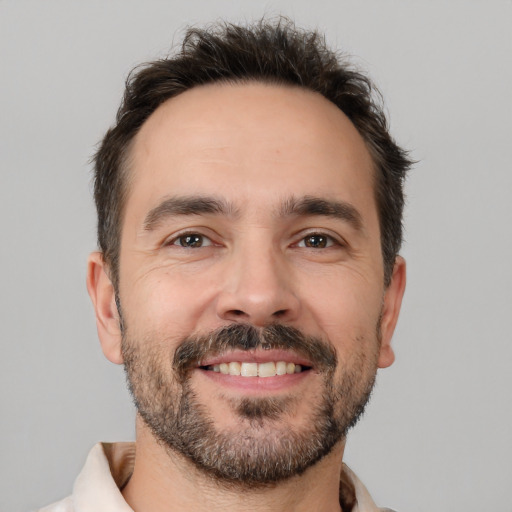 Joyful white adult male with short  brown hair and brown eyes