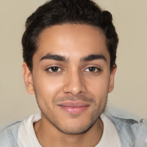 Joyful latino young-adult male with short  brown hair and brown eyes