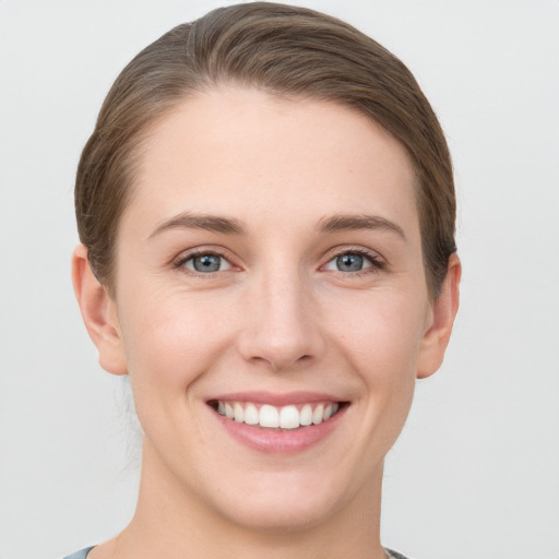 Joyful white young-adult female with short  brown hair and grey eyes