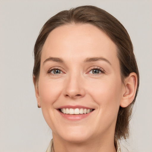 Joyful white young-adult female with medium  brown hair and grey eyes