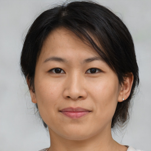 Joyful asian young-adult female with medium  brown hair and brown eyes