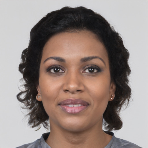 Joyful black young-adult female with medium  black hair and brown eyes