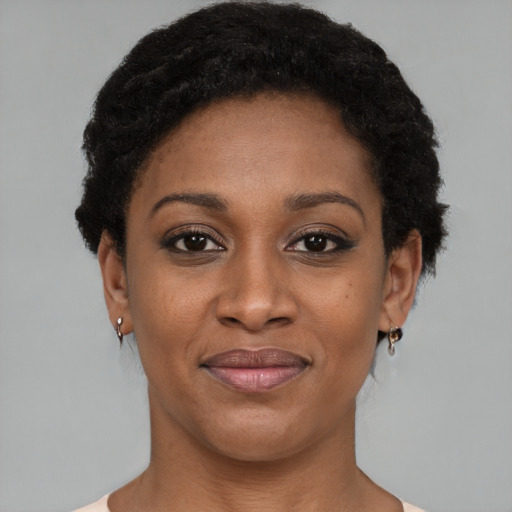 Joyful black young-adult female with short  black hair and brown eyes
