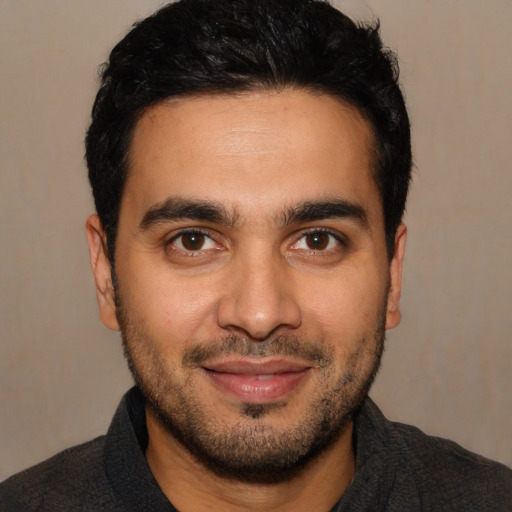 Joyful latino young-adult male with short  black hair and brown eyes