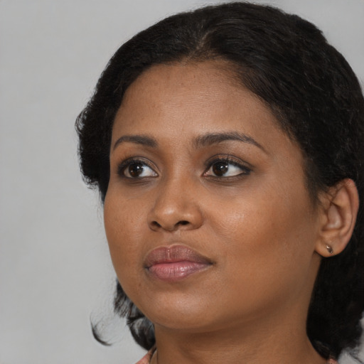 Joyful black young-adult female with medium  black hair and brown eyes