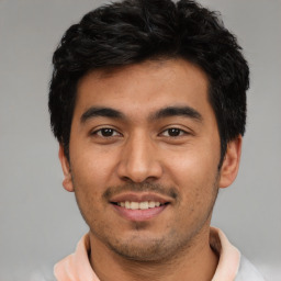 Joyful latino young-adult male with short  black hair and brown eyes