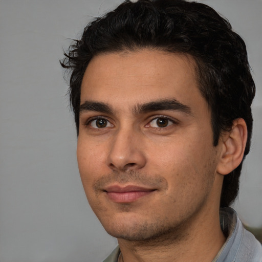 Joyful white young-adult male with short  black hair and brown eyes