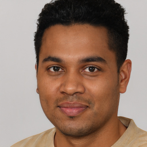 Joyful black young-adult male with short  black hair and brown eyes