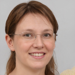 Joyful white young-adult female with medium  brown hair and grey eyes