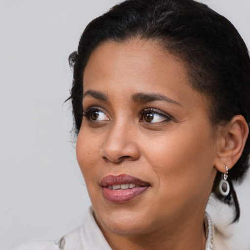Joyful black young-adult female with medium  brown hair and brown eyes