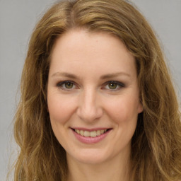 Joyful white young-adult female with long  brown hair and green eyes