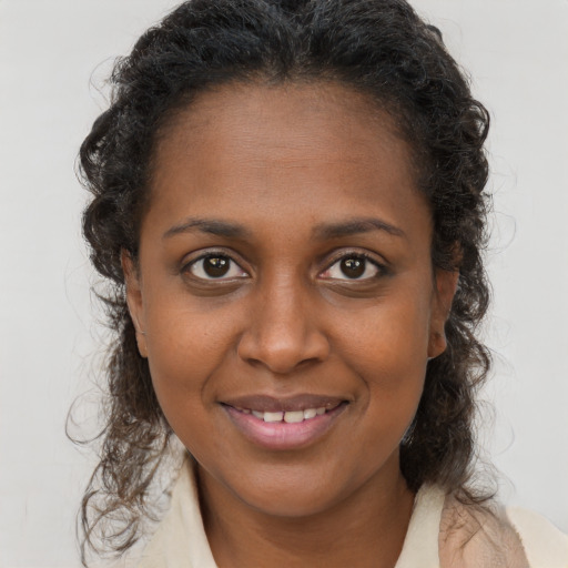Joyful black young-adult female with long  brown hair and brown eyes