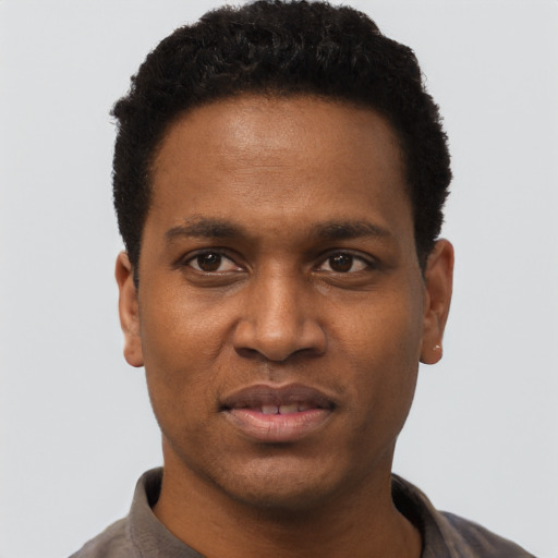 Joyful black young-adult male with short  black hair and brown eyes