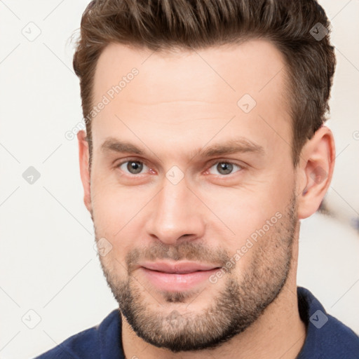 Joyful white young-adult male with short  brown hair and brown eyes