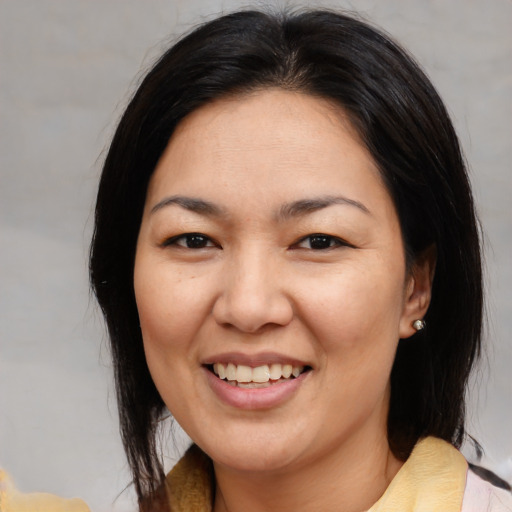 Joyful asian adult female with medium  brown hair and brown eyes