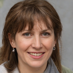 Joyful white adult female with medium  brown hair and grey eyes