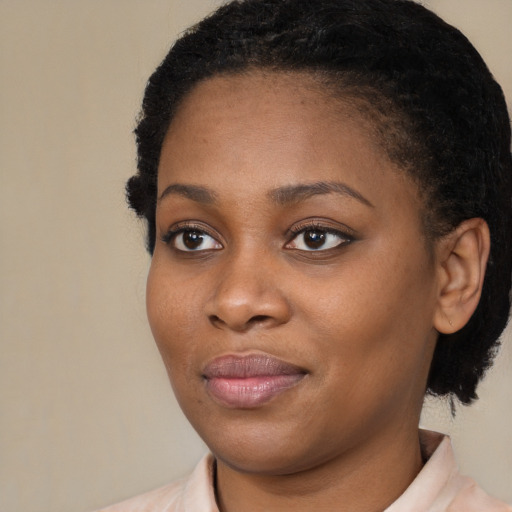 Joyful black young-adult female with short  brown hair and brown eyes