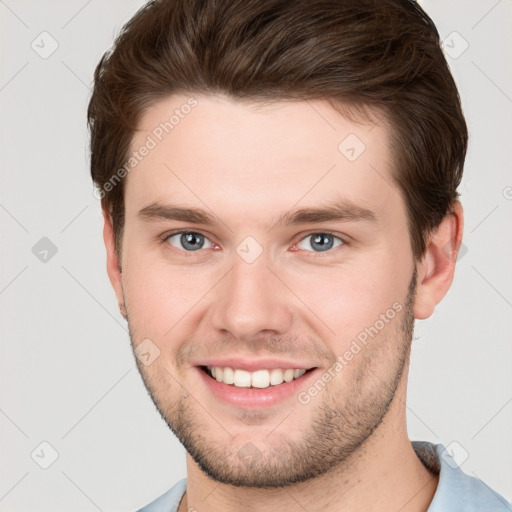 Joyful white young-adult male with short  brown hair and grey eyes