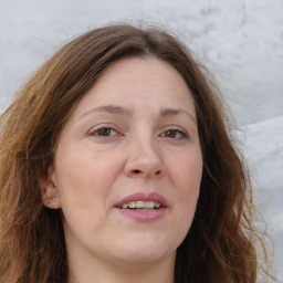 Joyful white adult female with long  brown hair and grey eyes